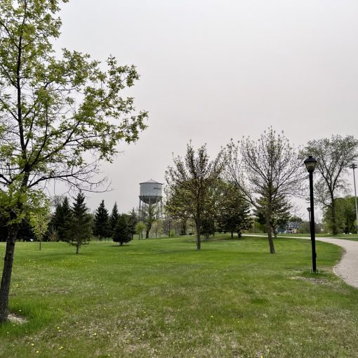 Pathway stretches through a park, with a large civic water tower in the background.