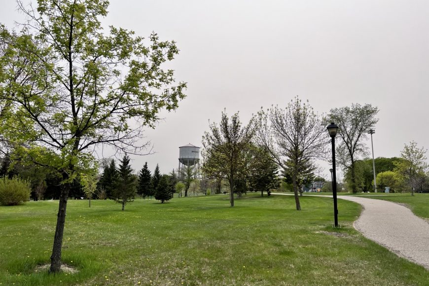 Pathway stretches through a park, with a large civic water tower in the background.